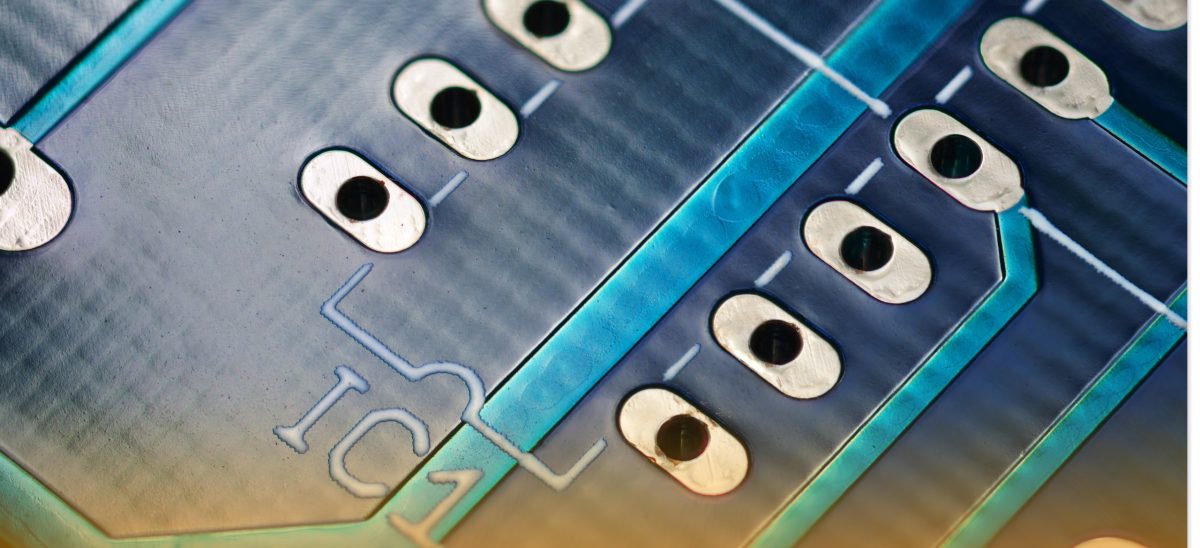 A close picture of plated through-holes on a blue PCB