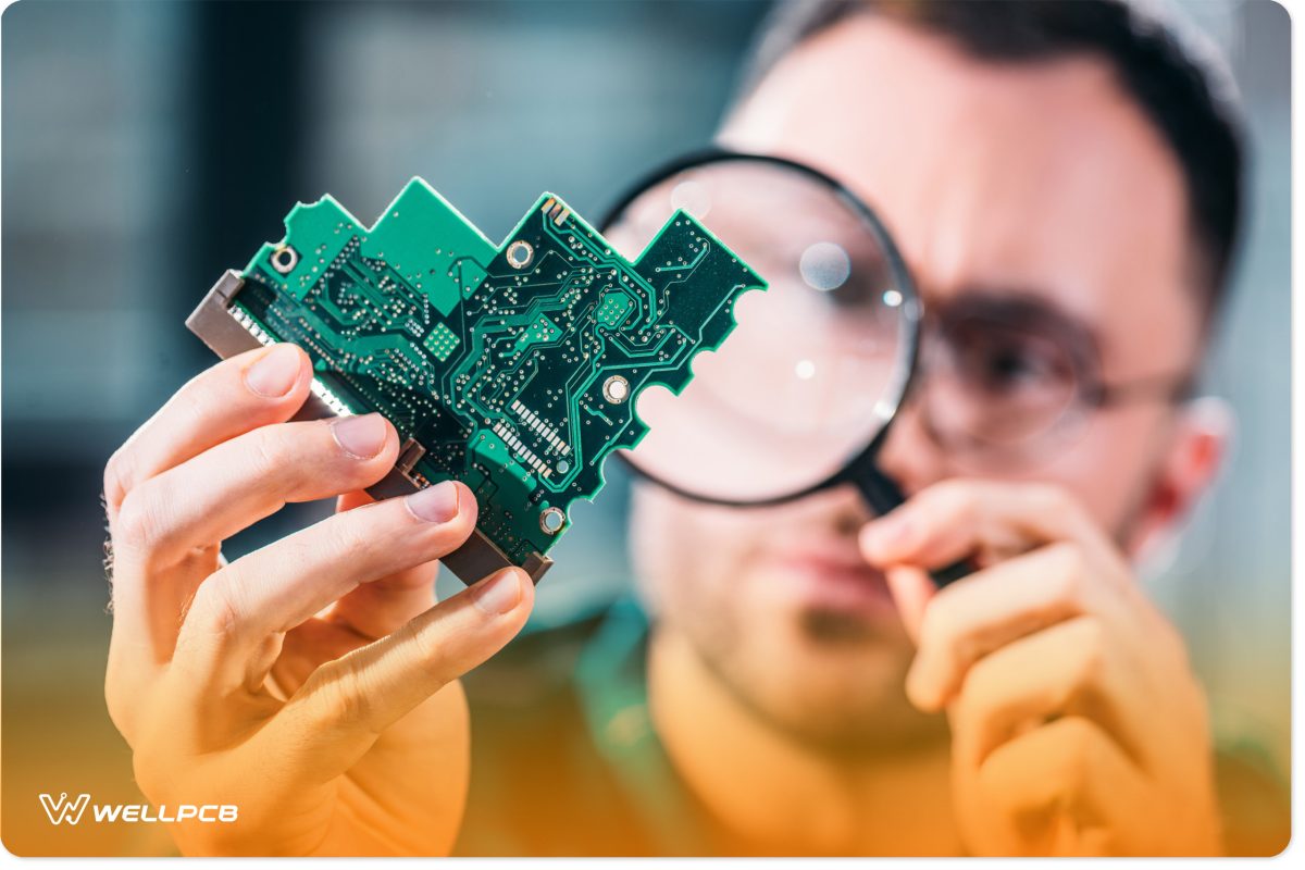 Close-up view of man looking at circuit board through a magnifying glass